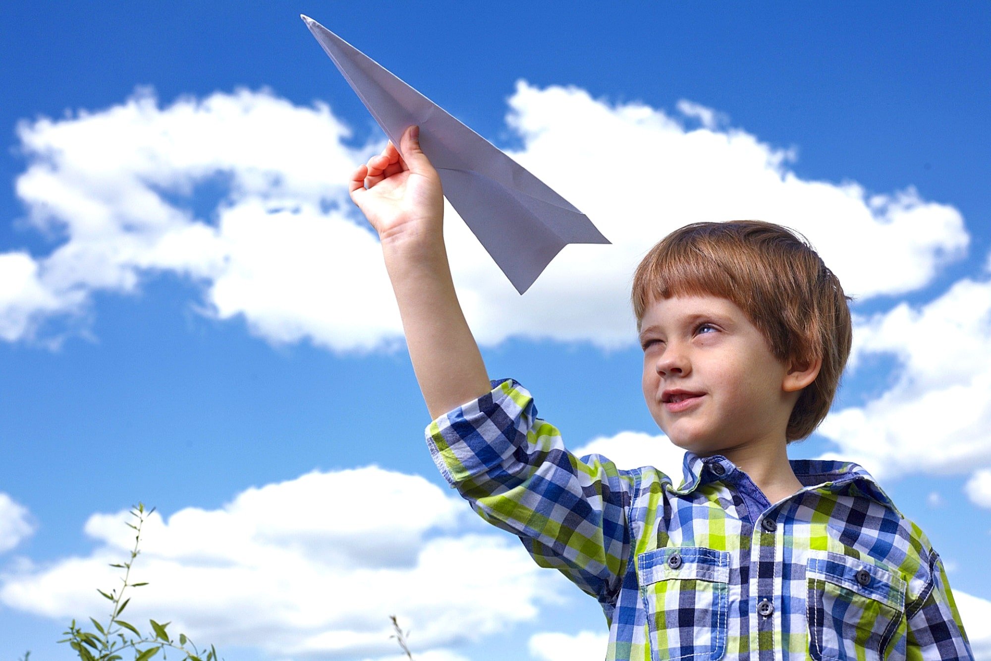 紙飛行機を飛ばす少年